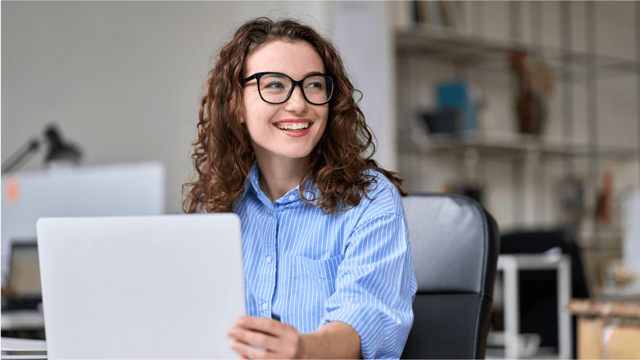 Uśmiechnięta kobieta w okularach i niebieskiej koszuli.