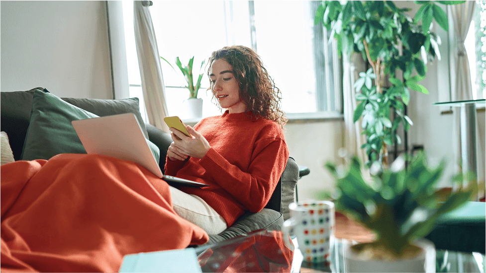 Kobieta z telefonem w ręku siedząca na kanapie